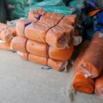 Cuộn lưới bao che công trình màu cam chụp gần trong kho