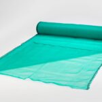 Cuộn lưới bao che công trình màu xanh ngọc trải một phần