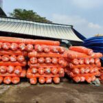 Kho lưới bao che công trình màu cam với nhiều cuộn hàng